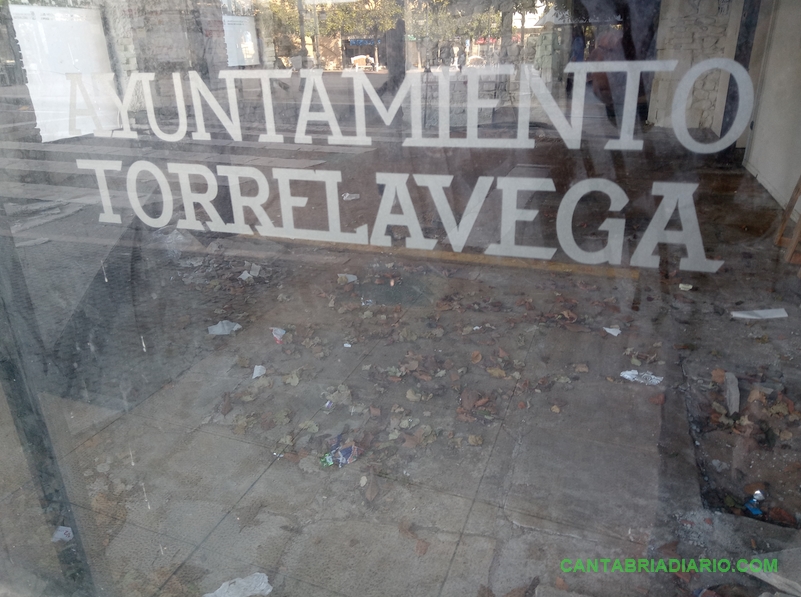 Una pocilga en el centro de Torrelavega - Escombros, papeles, envoltorios y otros desperdicios son visibles a través de los cristales del local abandonado